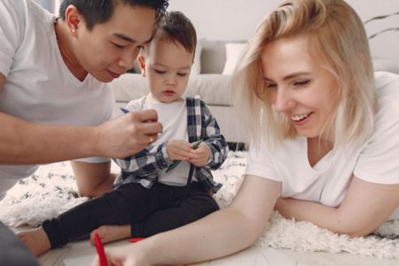 Mom, dad and child coloring on the floor together